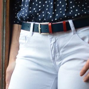ceinture en cuir bicolore bleu et rouge porté sur un jean blanc