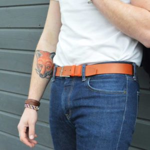 ceinture en cuir bicolore marron et orange porté sur un jean brut